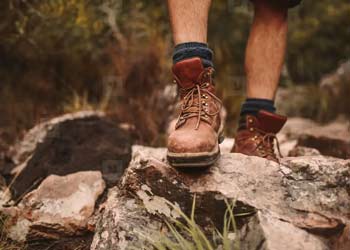closeup of feet hiking over rocks