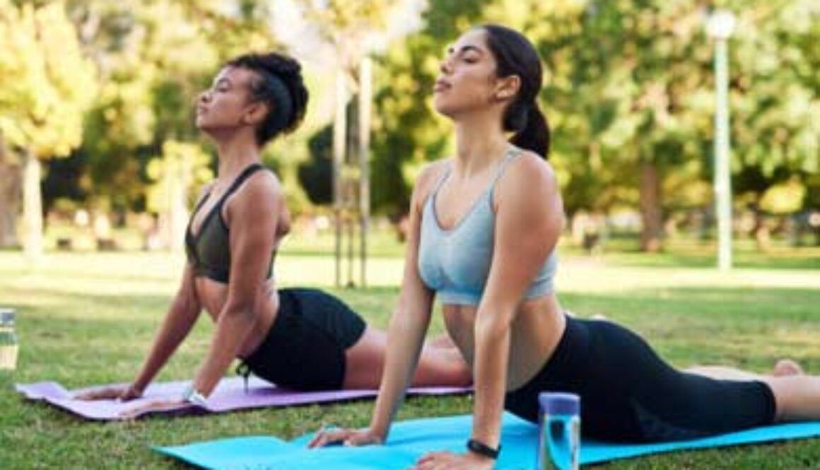 two women posing on mat doing pilates